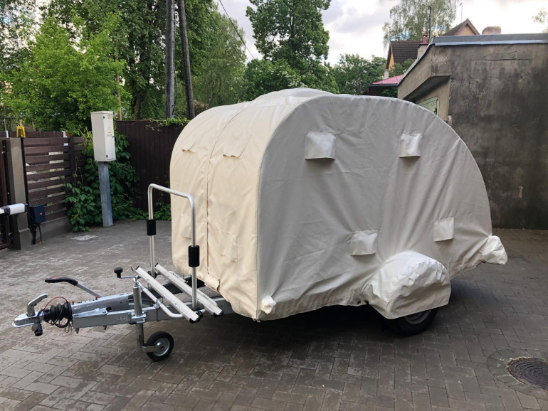 Teardrop trailer covered by a weather protection cover